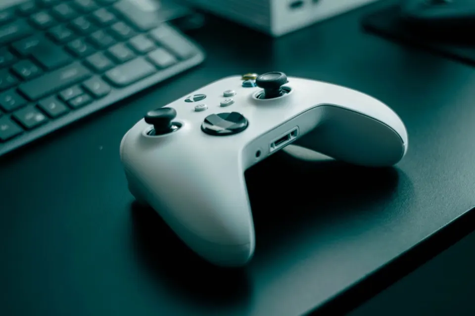 Tay cầm Xbox màu trắng đặt trên bàn làm việc
