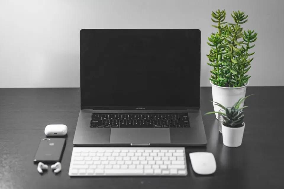 Bàn làm việc với MacBook, bàn phím và chuột rời màu trắng