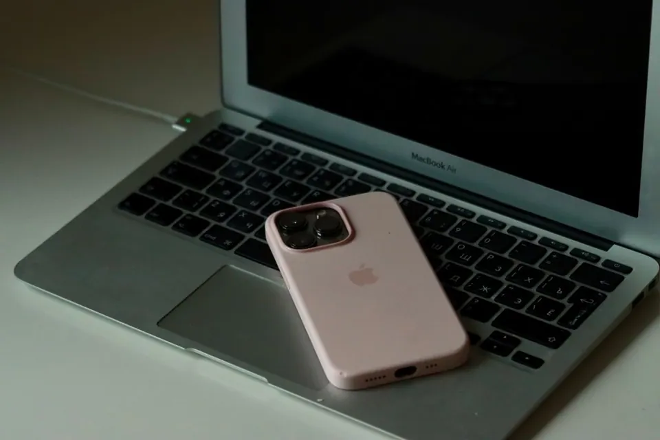 iPhone màu hồng đặt trên MacBook Air