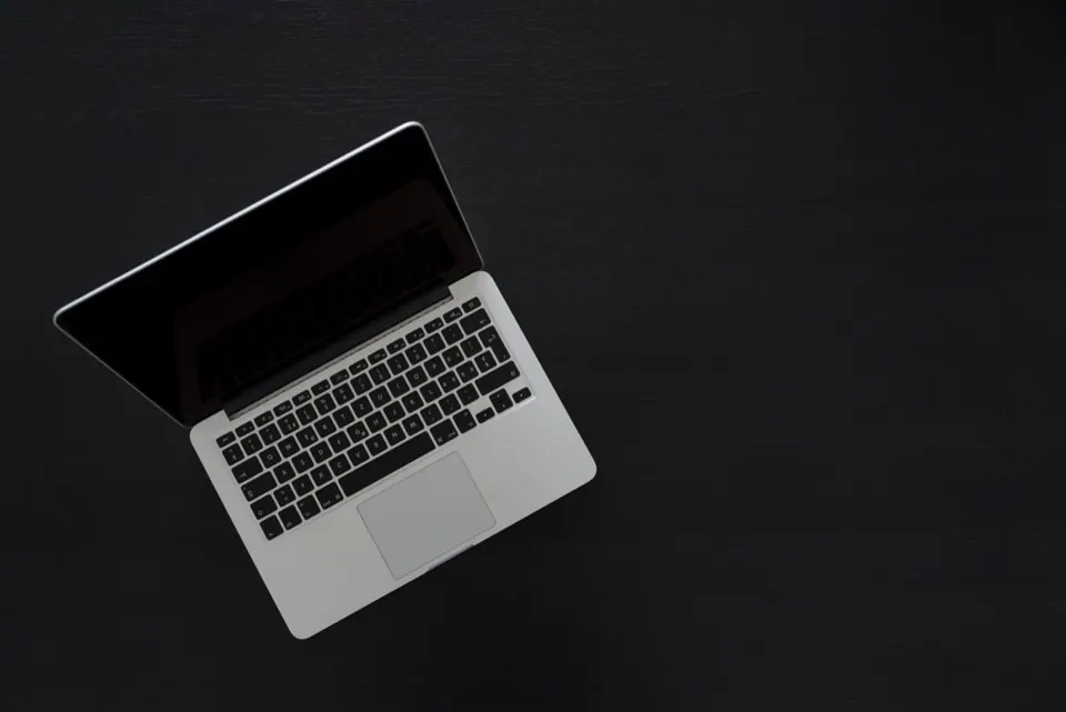 MacBook Pro mở trên bàn tối màu nhìn từ trên xuống