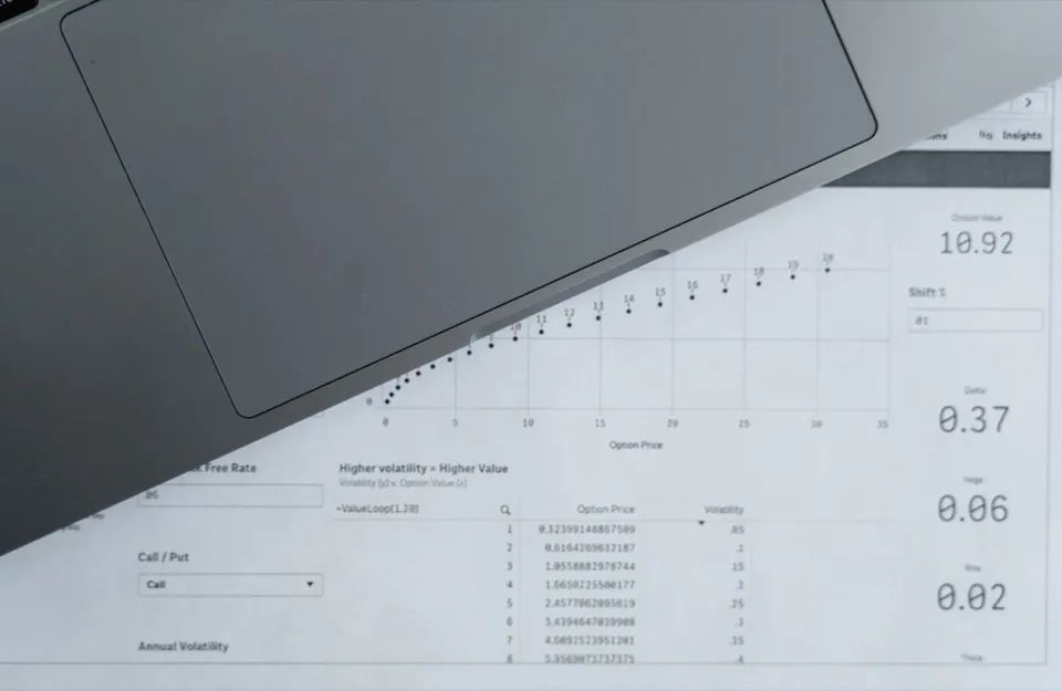 Bàn di chuột MacBook đặt cạnh bảng số liệu in giấy