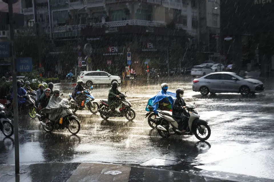 Người đi xe máy dưới mưa trên đường phố Việt Nam