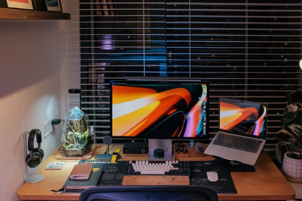 Góc làm việc với nhiều màn hình và MacBook trên bàn