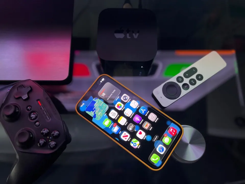 Apple TV, iPhone và tay cầm chơi game đặt cạnh nhau