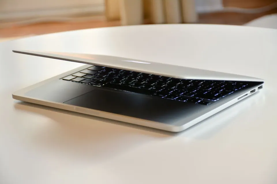 MacBook đang được gập nửa chừng trên bàn trắng