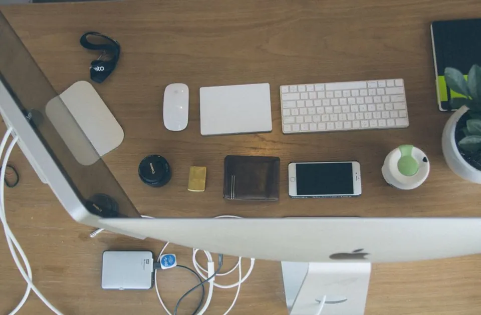 Bàn làm việc nhìn từ trên xuống với bàn phím, chuột, trackpad Apple và các phụ kiện