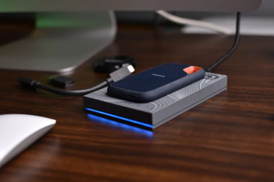 Ổ SSD di động SanDisk cắm cáp trên bàn gỗ