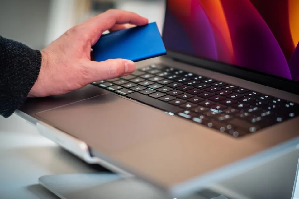 Tay cầm ổ SSD di động bên cạnh MacBook Pro